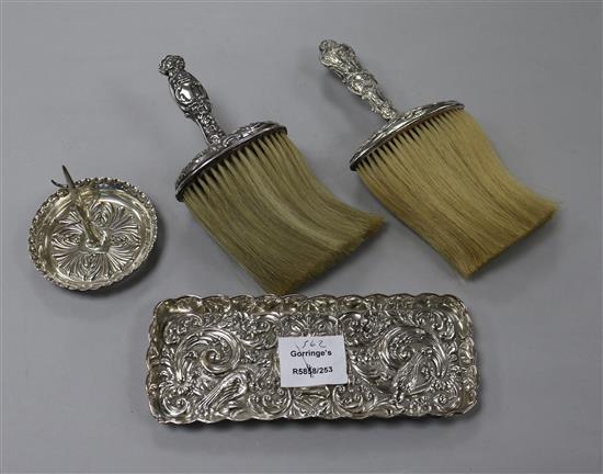 An Edwardian repousse silver pin tray, a Victorian silver ring tree and two silver handled brushes.